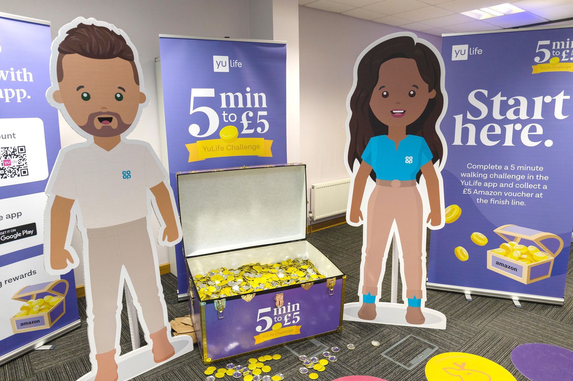 A chest of fake coins, two emoji cardboard cut-outs and some signs at a sign-up event as a Co-op depot.